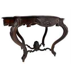 19th century Irish rosewood centre table, the shaped and moulded top over shaped apron carved with scrolled foliage, on serpentine supports carved with bell flowers, the supports united by anthemion carved finial and s-scroll x-framed stretchers