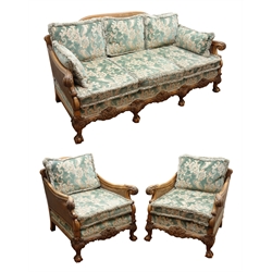  Early 20th century walnut framed bergere suite, the acanthus carved outsplayed arms with double caned sides, scroll and leaf carved frieze on cabriole legs with claw and ball feet, with loose back and seat cushions, comprising Sofa, W202cm, H94cm, D93cm, Two chairs, W80cm, H94cm, D93cm, Stool, W71cm, D42cm, H38cm,   
