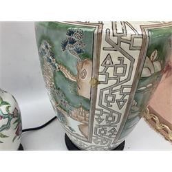 Four Oriental ceramic table lamps, to include example modelled as a ginger jar decorated with birds, figures and flowers, another example of tapering form decorated with a river and pagoda landscape scene, and pair of smaller lamps decorated with blossoming branches, all with pink tasselled fabric shades and upon circular hardwood bases, largest H38cm excl fitting