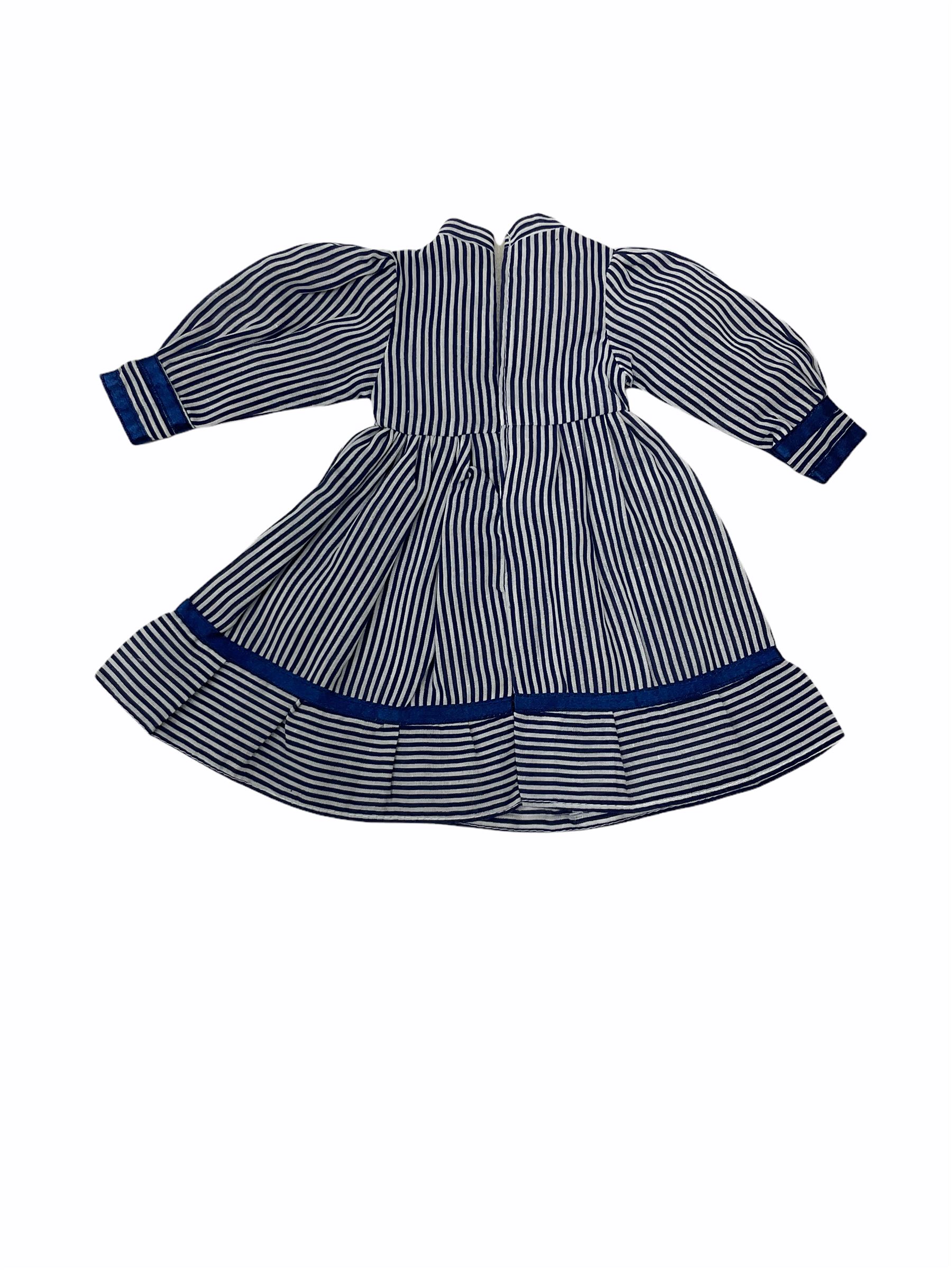 Heidi Ott doll in tartan dress, navy floral dress with white lace and ribbon detailing, striped blue and white dress and a 'Head to Toe' book