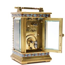 French- Edwardian miniature brass 8-day timepiece carriage clock with cloisonné panels to both base and cornice and paste gems to the front columns, decorative porcelain dial with a floral swag, blue Arabic numerals, minute track and pieced steel hands, square viewing glass to the top with a silvered lever escapement, with original leather bound traveling case.