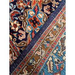 Persian indigo and rust ground carpet, the field decorated with multiple shaped floral design panels with lighter blue ground central panels forming medallion, guarded border decorated with stylised plant motifs 