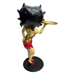 Contemporary Betty Boop waitress figure, modelled standing with one hand holding a circular tray, dressed in a red dress with gold accents, on a black circular base