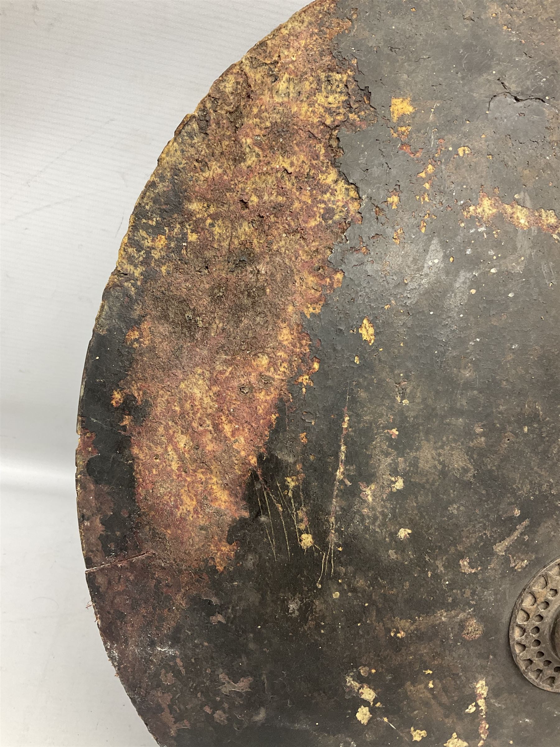 Indian black lacquered hide shield/dhal, of circular convex form fitted at its centre with four pierced iron bosses, each of hemispherical form with wide brims, the bosses corresponding on the inside with four iron rings for enarmes D53.5cm