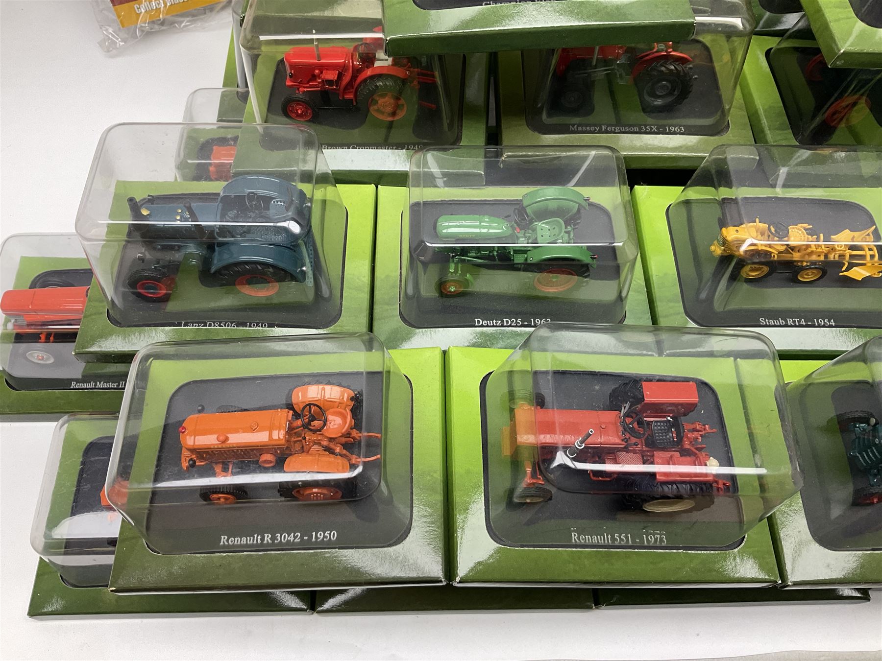 Eighteen issues of Tractors and The World of Farming magazine, together with sixty diecast tractors, all in original packaging, in three boxes 