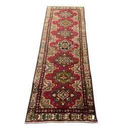 Persian red ground rug, repeating patterned spine in multicolour fashion, floral inner boarder geometric shaped outer 