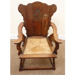  Early 20th century oak chair, carved crests on the splat, drop in rush seat, turned out splayed supports joined by square stretchers, W57cm   