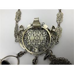 19th century continental silver plated chatelaine, the main body flanked with winged mythical beasts and central soldier slaying a dragon supporting three suspended items to include velvet lined small basket and long clasped filigree chain, together with a thimble