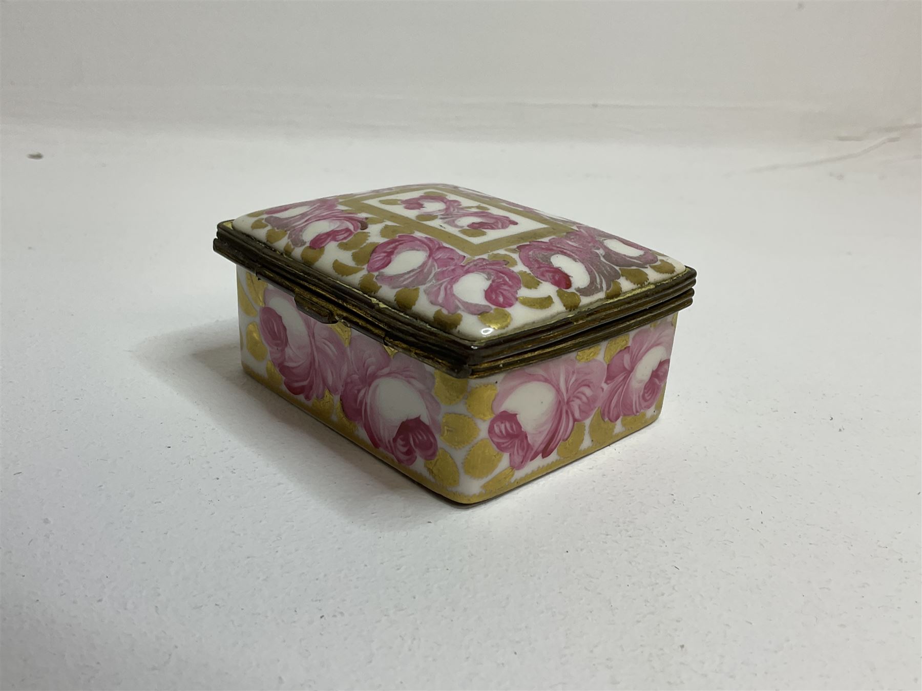 Early 19th century Swansea box of rectangular form, densely decorated with painted pink cabbage roses and gilt foliage upon plain ground, the hinged lid opening to reveal interior painted with two further roses upon plain ground, marked Swansea. in gilded lettering beneath, W7cm H3.5cm D5.5cm