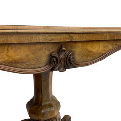 Victorian figured walnut card table, the moulded fold-over top with circular baize playing surface, faceted vase shaped baluster column, on quadruple splayed and s-scroll supports, brass castors