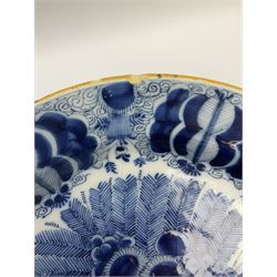 18th century Delft blue and white peacock pattern dish, painted with a fan of peacock feathers behind an urn of fruit and flowers, D34.5cm. 