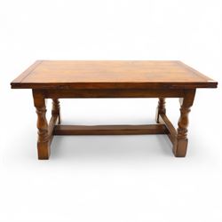 20th-century good quality solid oak extending refectory table, planked, constructed rectangular top with two extending leaves on the underside above a plain frieze raised on four turned baluster supports united by stretchers on block feet, 260cm extended