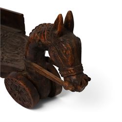 Indian carved wooden tray on wheels, the front carved as a horses head, the cart with foliate details, H28cm