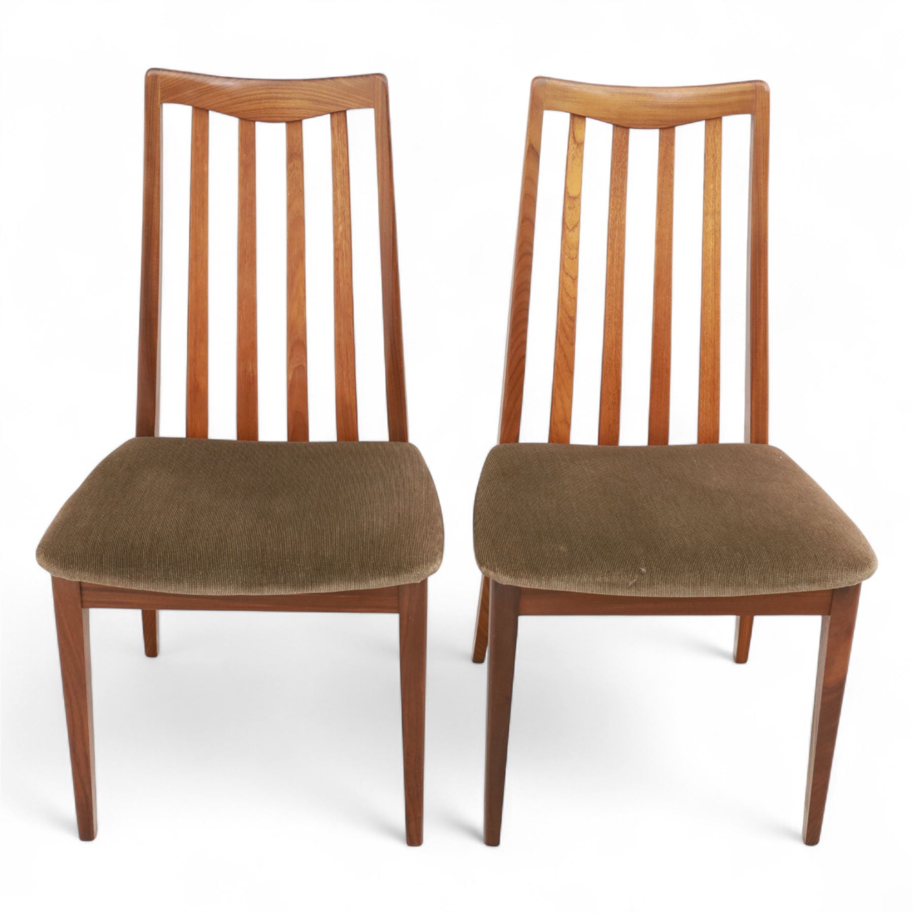G Plan - mid-20th century teak extending dining table, oval top with integrated extension leaf, raised on tapering legs, together with a set of six slat back dining chairs including two carvers, upholstered in dark green velour (Extends to 210cm)