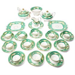 19th century porcelain tea service decorated with a border pattern of yellow leaves on a g...