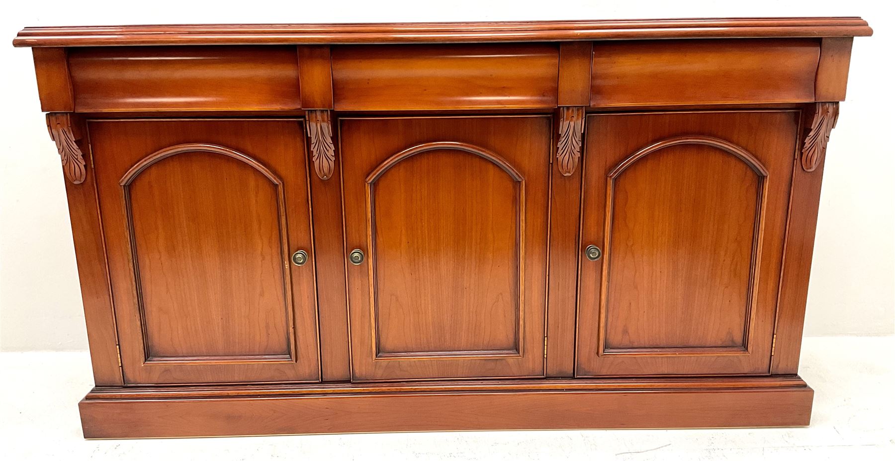 Waring & Gillow - cherry wood sideboard, three drawers above three cupboards, skirted base