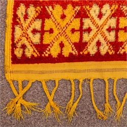 Moroccan Berber hand knotted runner, the red and orange ground woven with an all over lattice of lozenge motifs enclosing small geometric devices, within narrow patterned borders, finished with fringe to one end