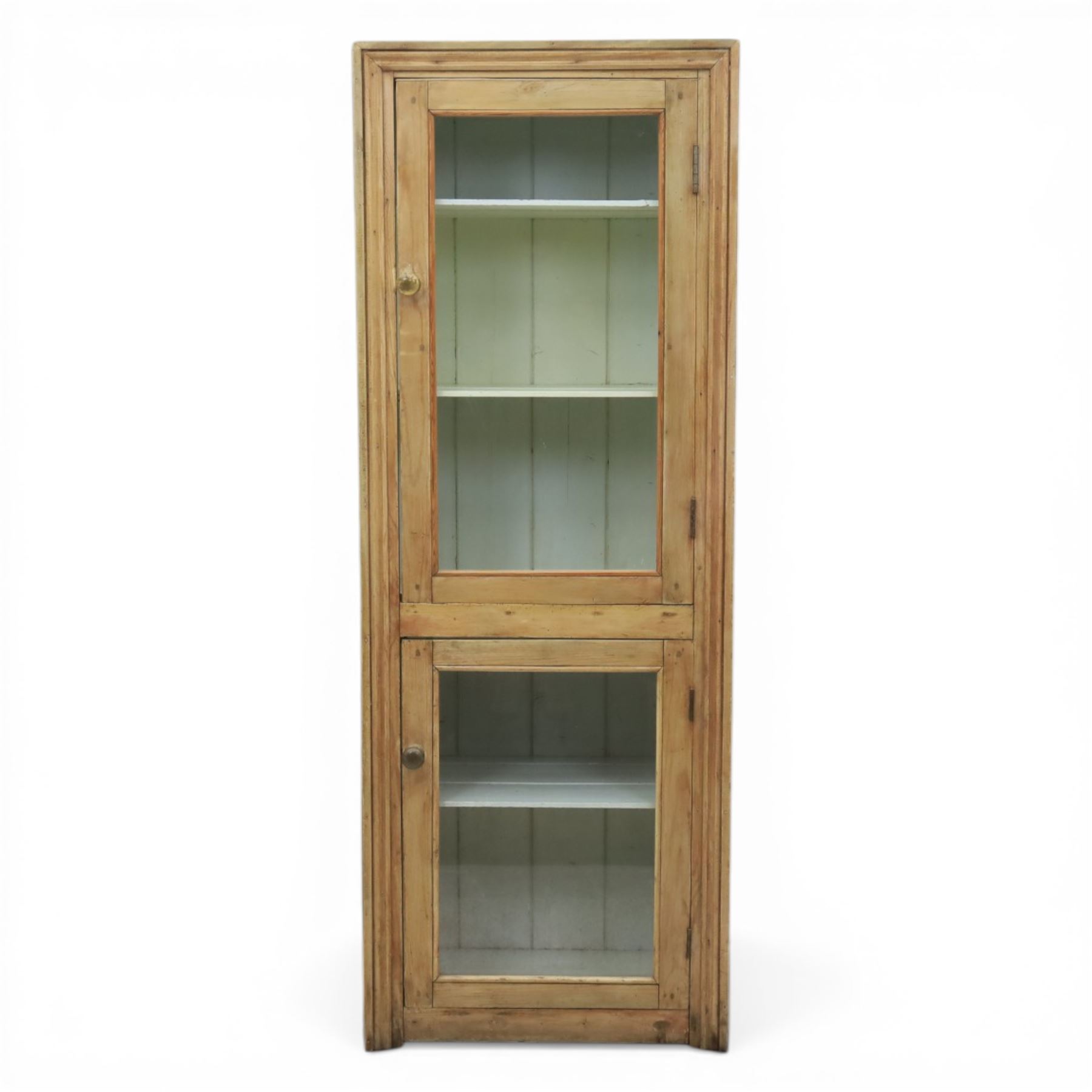 Early 20th century waxed pine kitchen cupboard, rectangular form with moulded top, enclosed by two glazed doors revealing painted interior with shelves, boarded sides and back, fitted with brass knob handles