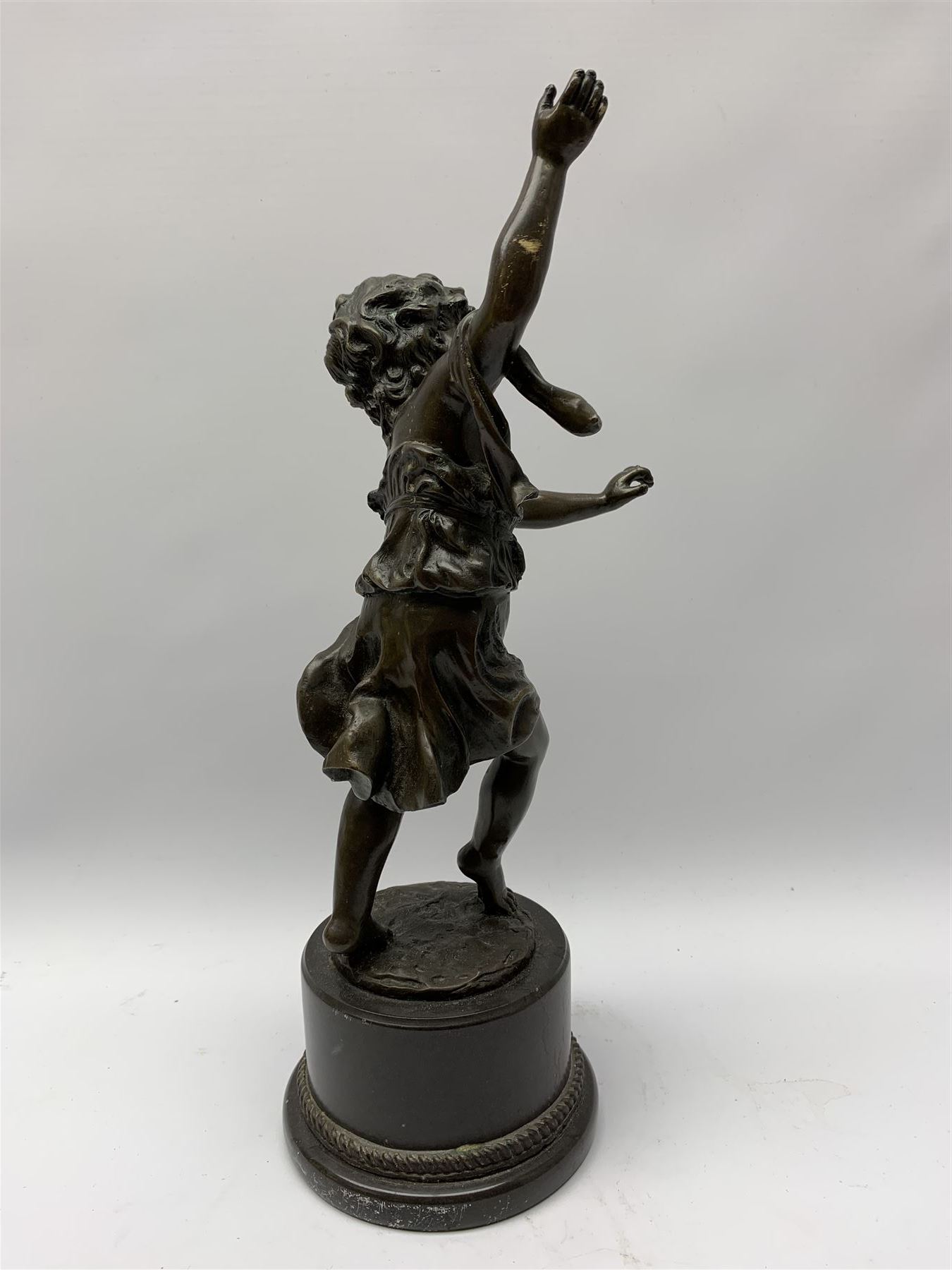 After E Plat, bronze modelled as a dancing child, signed E. Plat, upon cylindrical black marble base, H40cm