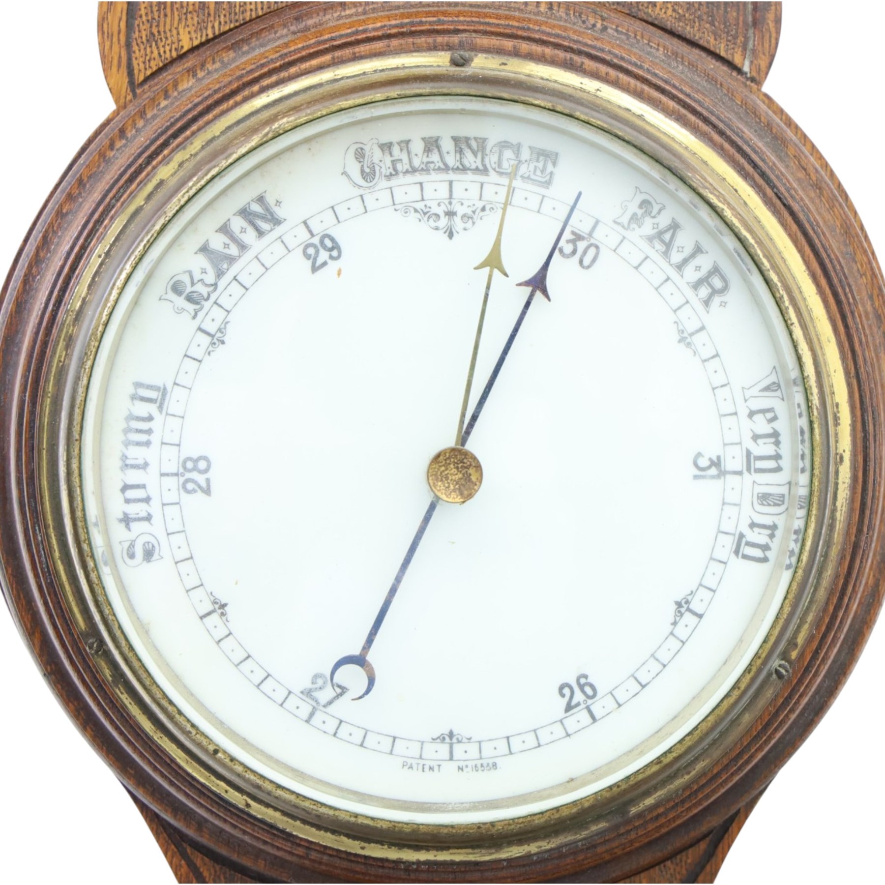 Late Victorian carved oak aneroid barometer, the foliate crest above a glazed thermometer and circular dial, with further carved decoration below, H 75cm