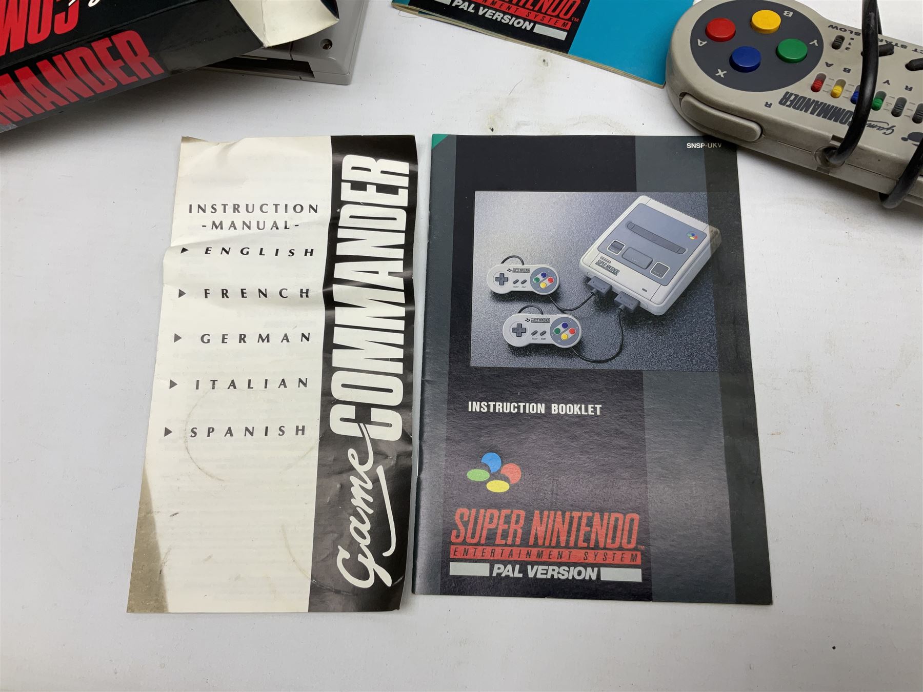 Two Super Nintendo Entertainment System (PAL) controllers, accessories and games. Super NES Game Commander with original box and instruction booklet, Super NES Nintendo Scope (1992) transmitter gun, receiver, Super NES Nintendo Scope 6 game with original instruction booklets. Further games to include ‘The Legend of Zelda a Link to the Past’, ‘Super Mario World’, ‘Super Mario Kart’, ‘The Lawnmower Man’, and ‘Exhaust Heat’, all with original instruction booklets. ‘PowerMonger’ and Disney’s ‘Aladdin’ game cartridges only 