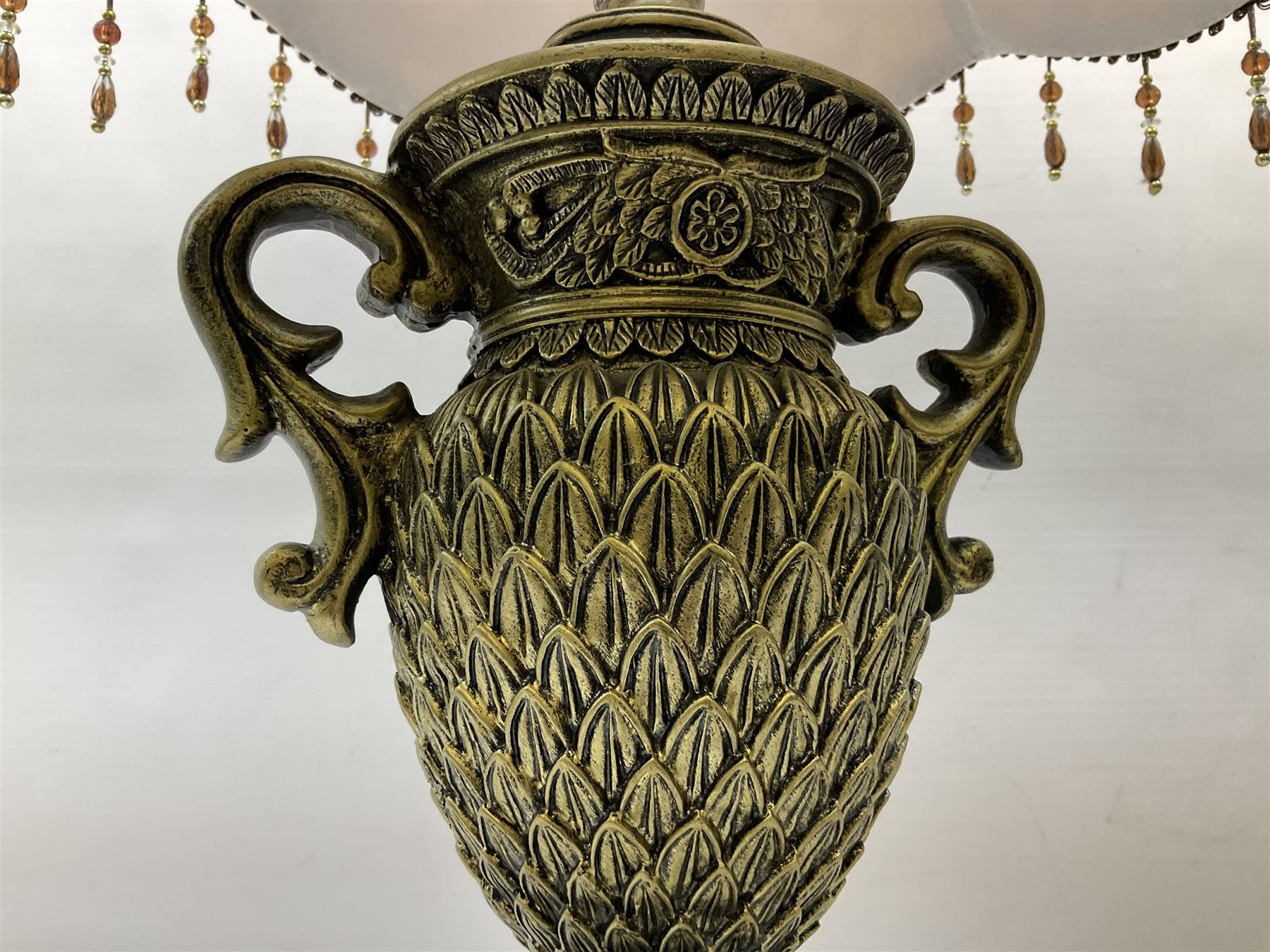 Pair bronzed amphora lamps with pineapple decoration, scroll handles and foliate base with scrolled feet together with pair peach ground shades and raised floral pattern H76cm (2)