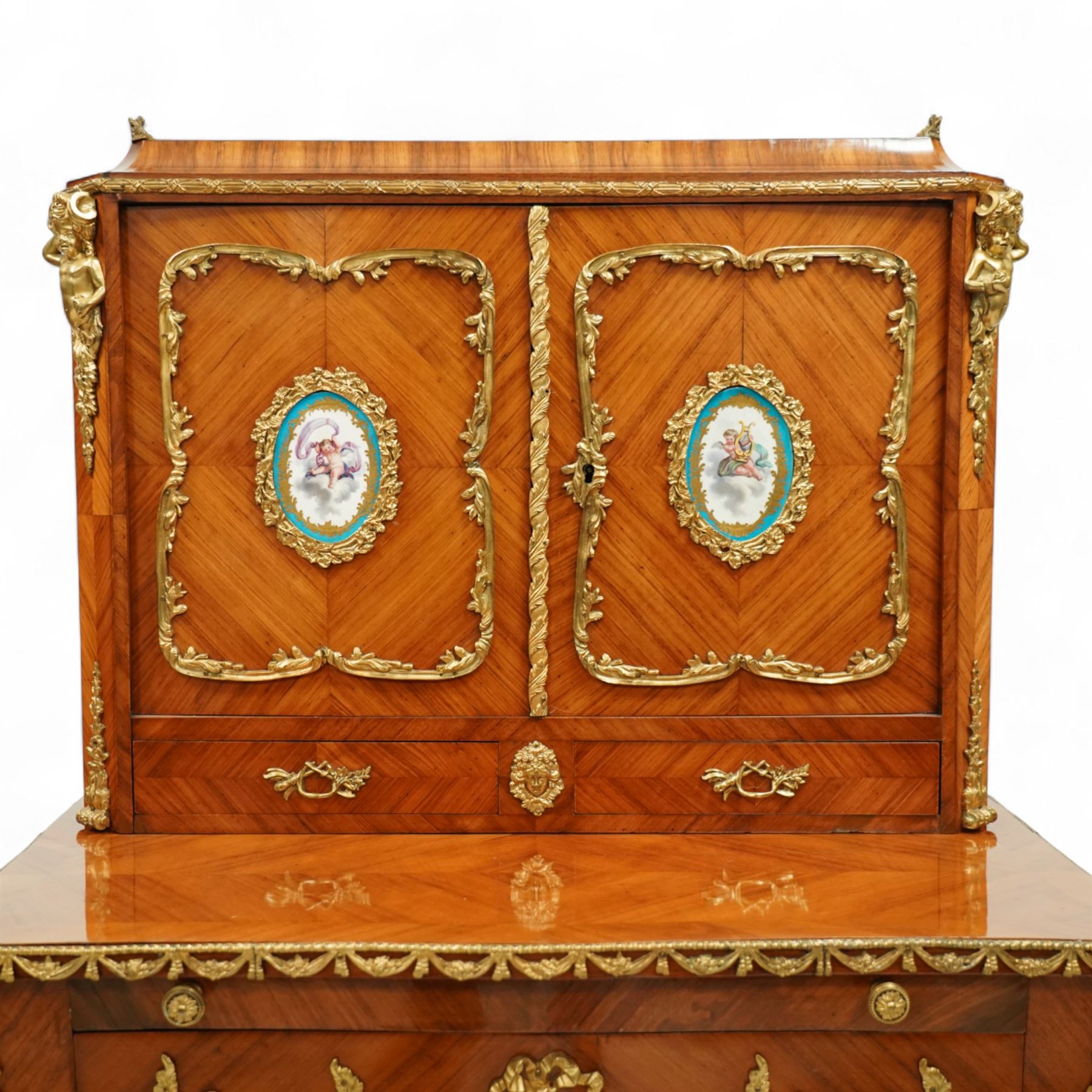 Late 19th century French Louis XV style kingwood and ormolu mounted bonheur du jour, the upper section with a pierced three-quarter gallery over a pair of cupboard doors inset with Sèvres-style porcelain portrait plaques, enclosing a shelved interior over two short drawers, the serpentine top and apron richly mounted with gilt-bronze foliate and scroll motifs, single frieze drawer below on cabriole supports with acanthus cast sabots