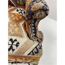 Late 20th century beech framed wingback armchair, sprung seat and back upholstered in kilim cover, acanthus carved cabriole supports with ball and claw feet