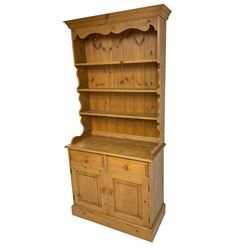 Waxed pine dresser, plate rack over two drawers and double cupboard, on plinth base