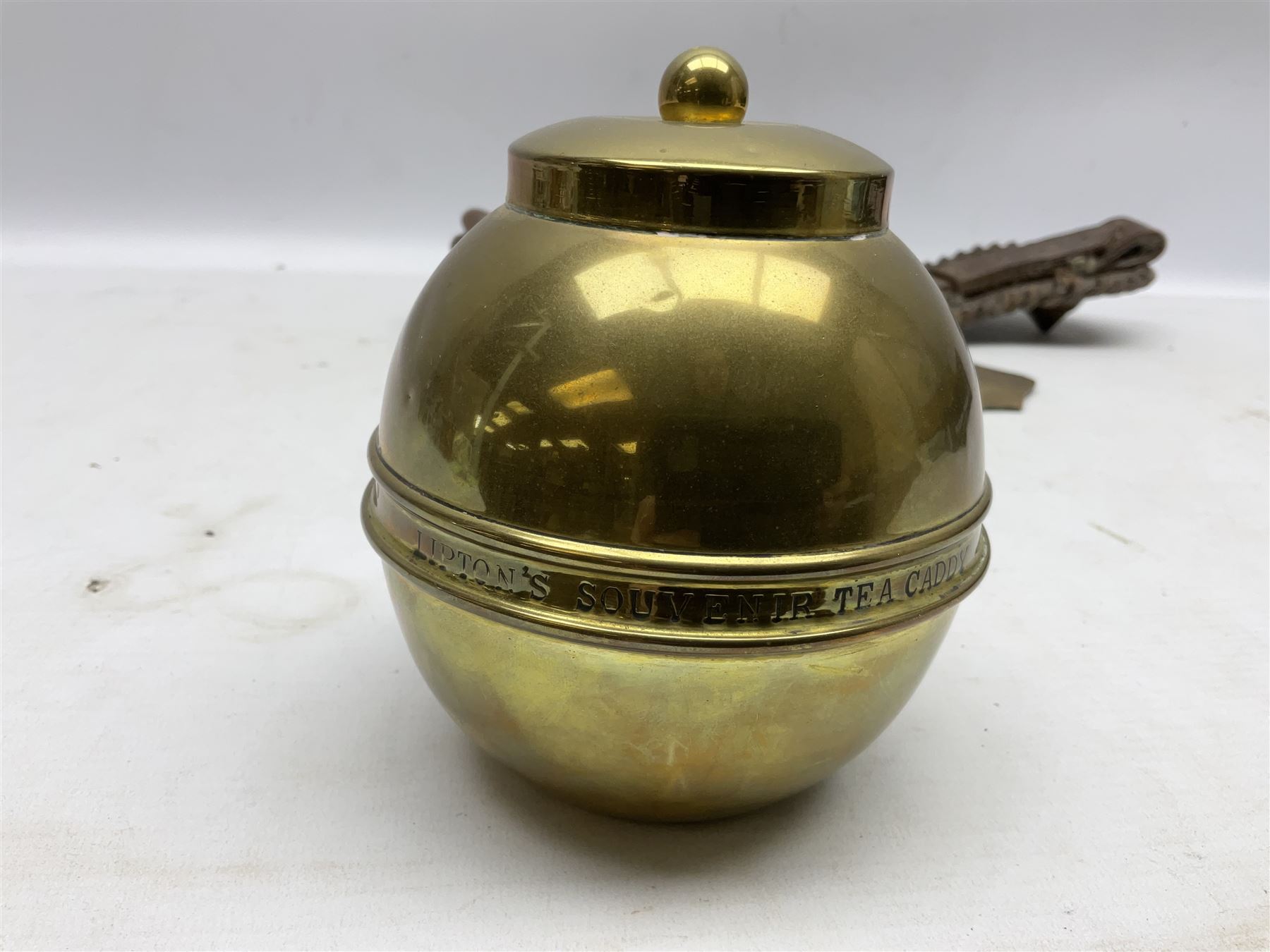 Victorian Queen Victoria record reign horse brass and H&SNCC Parade Badge of Merit 1911 horse brass, both on leather strap, together with 1924 British Empire Exhibition brass Lipton's souvenir tea caddy, strap L36cm