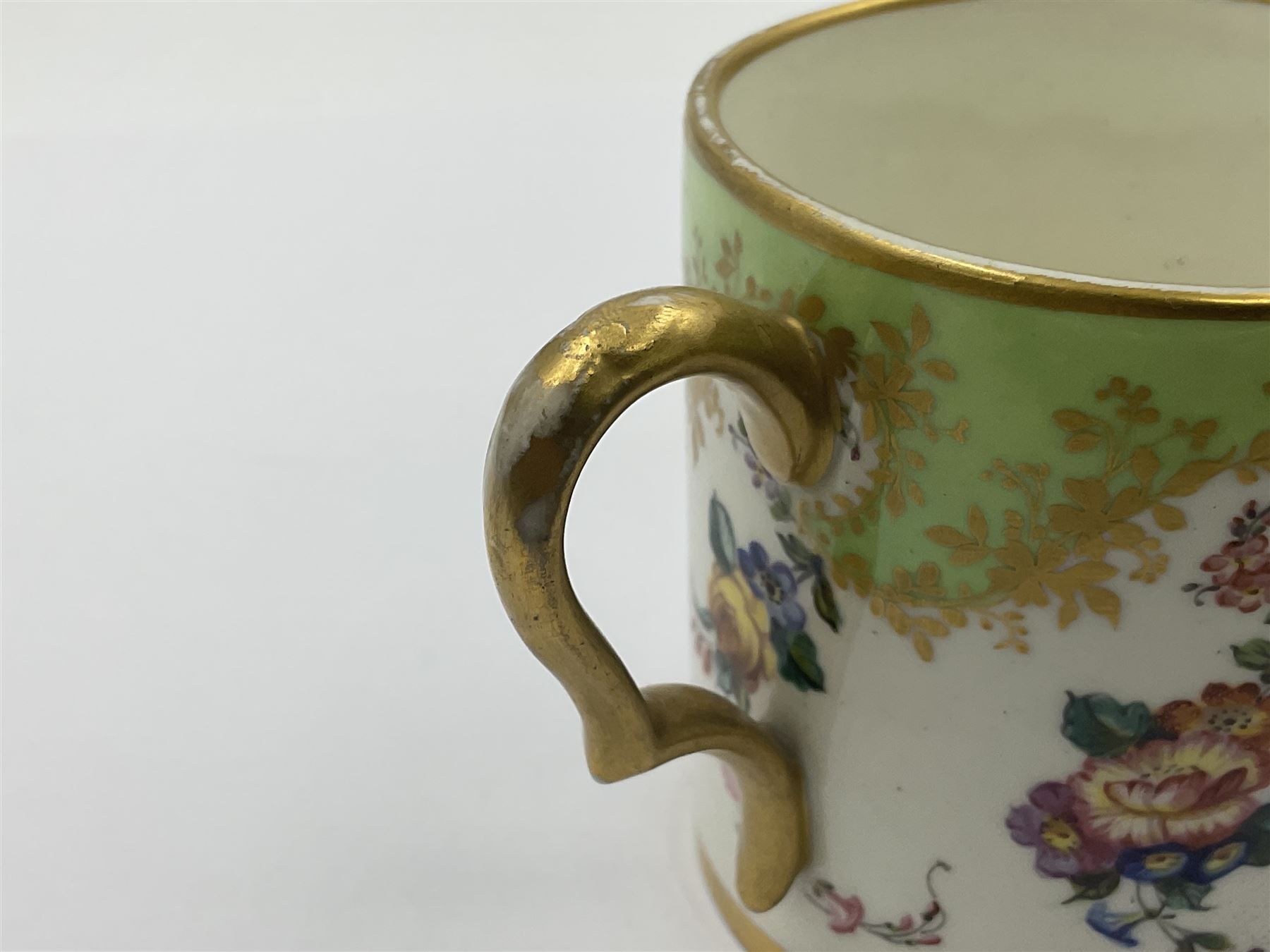 Sèvres soft paste porcelain coffee can and saucer with date code for 1754, painted and gilded with flowers, dangling from the shaped green border, interlaced LL monogram enclosing the date letter A above painters mark for Dodin, coffee can H7cm, saucer D14.5cm