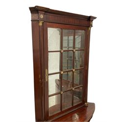 Pair of French Empire design corner cabinets, the straight-front upper section with canted corners and applied half-column pilasters, enclosed by mirror glazed door, the bow-front lower section enclosed by two doors with applied mouldings, mounted by cast metal floral rosettes, skirted base with cast gilt metal hairy paw brass feet