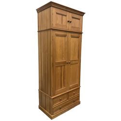 Solid pine double wardrobe, fitted with top box, enclosed by panelled doors, two short and one long drawer, on plinth base 