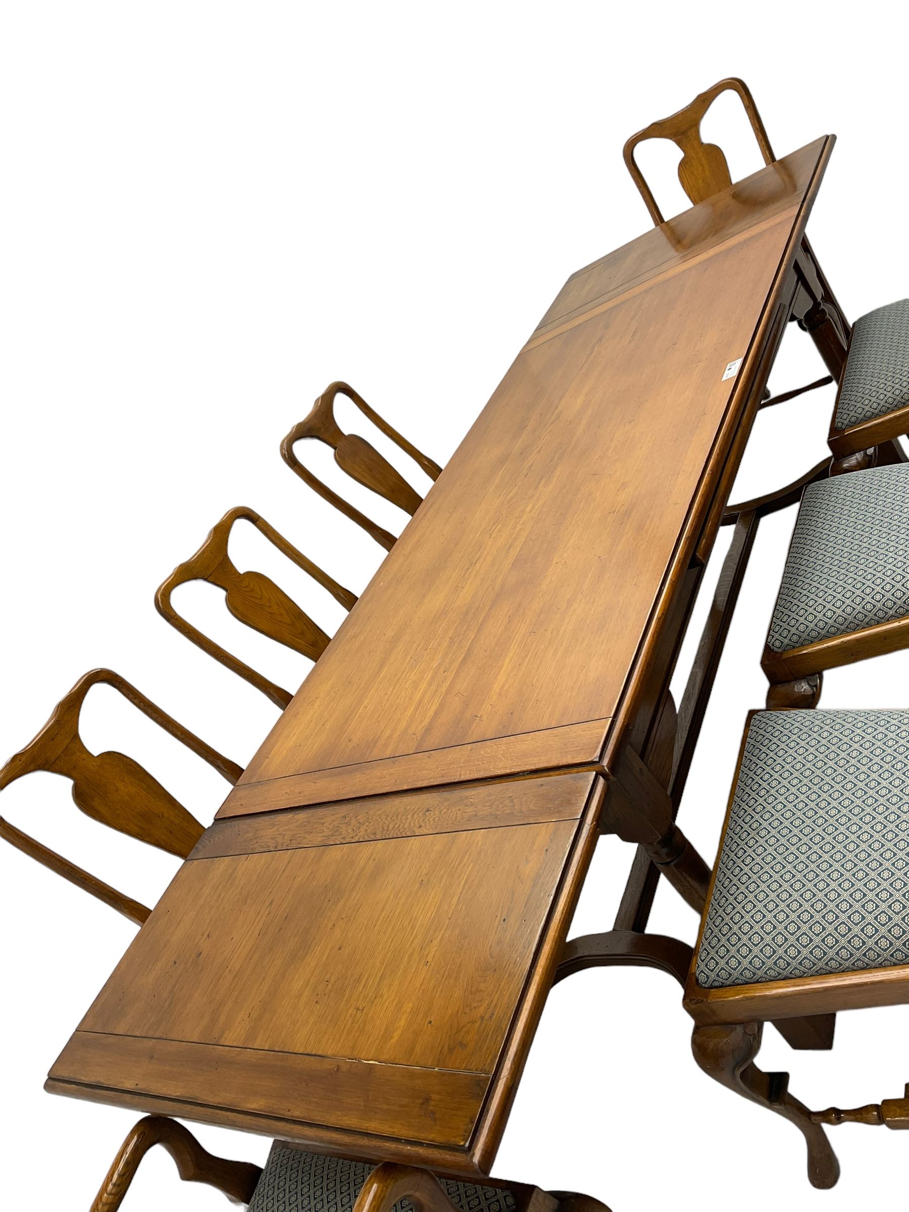 Late 20th century oak dining table, rectangular top with two draw leaf extensions, on turned supports united by moulded hayrake stretchers (180cm - 278cm x 90cm, H76cm); set of eight (6+2) oak dining chairs, shaped cresting rail over shaped splat back, upholster drop-in seat, on cabriole supports united by turned H-shaped stretchers 