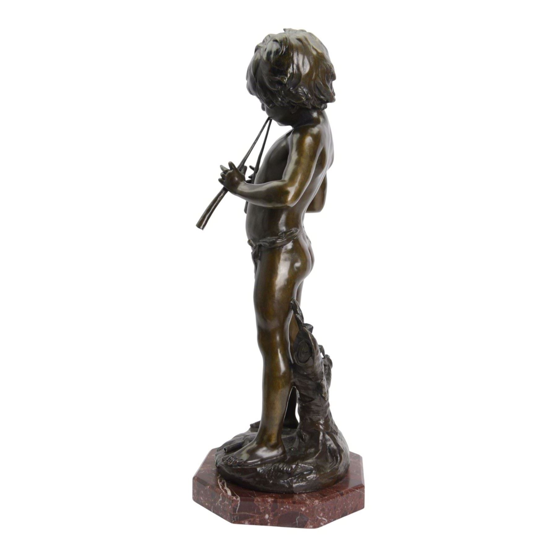 After Auguste Moreau (French 1834-1917): Large Bronze Figure of a Young Boy Playing the Aulos (Double-Reeded Pipes) standing upon a naturalistically modelled base detailed with tree stump and further pipe, signed Aug Moreau, upon octagonal red marble base, H73cm