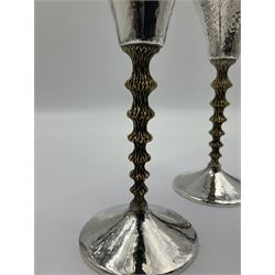Pair of modern silver goblets by Stuart Devlin, the tapering cylindrical bowls each with spot hammered decoration and gilt interiors, the parcel gilt stems with signature textured detailing and six graduating knops, upon conforming spreading circular foot, hallmarked Stuart Devlin, London 1976, H17.7cm
