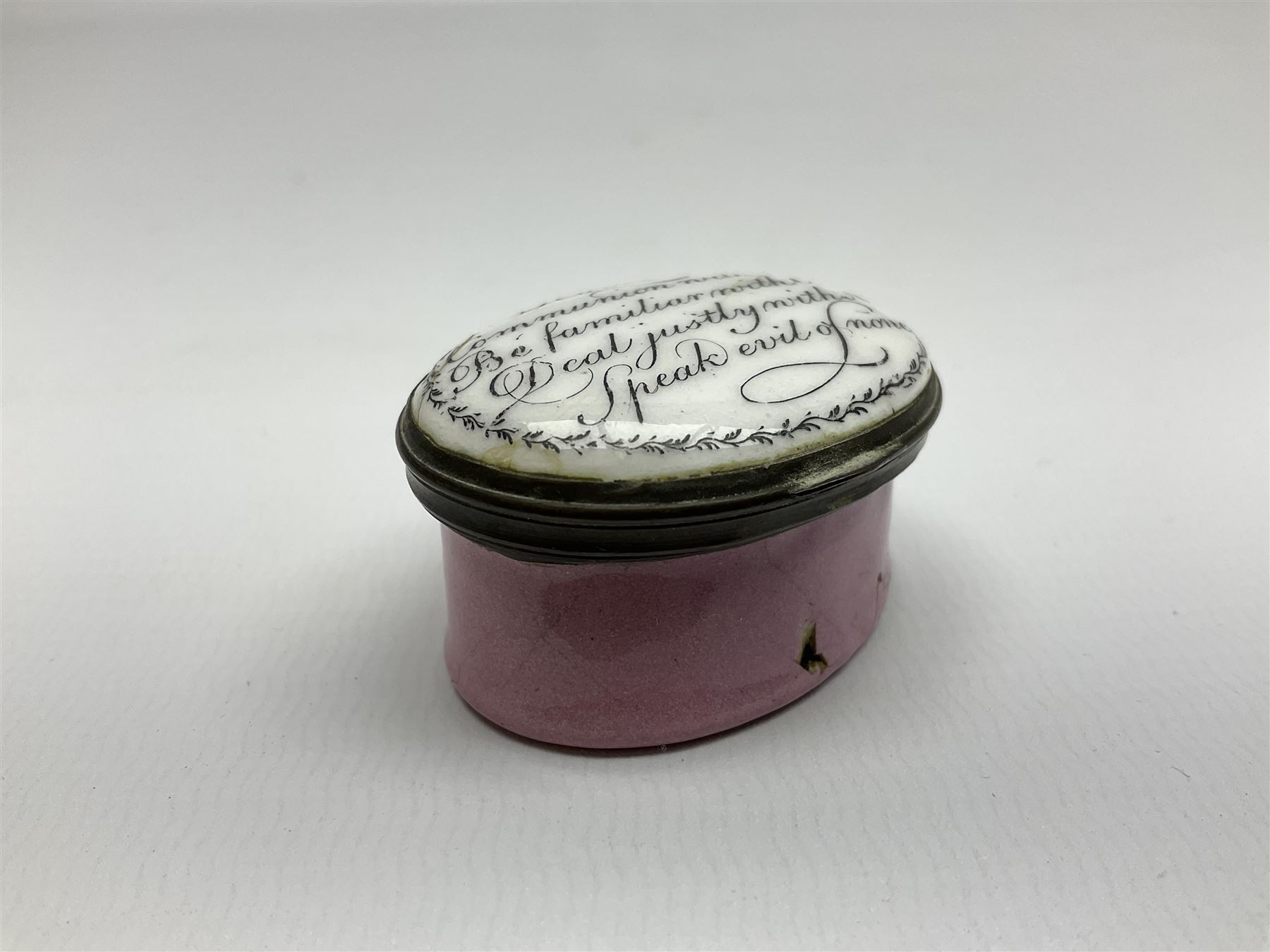 Late 18th century Staffordshire enamel patch box, of oval form with pink base, the hinged cover inscribed 'Have Communion with few, Be familiar with One, Deal justly with All, Speak evil of none' upon a white ground, opening to reveal mirror beneath, W4cm