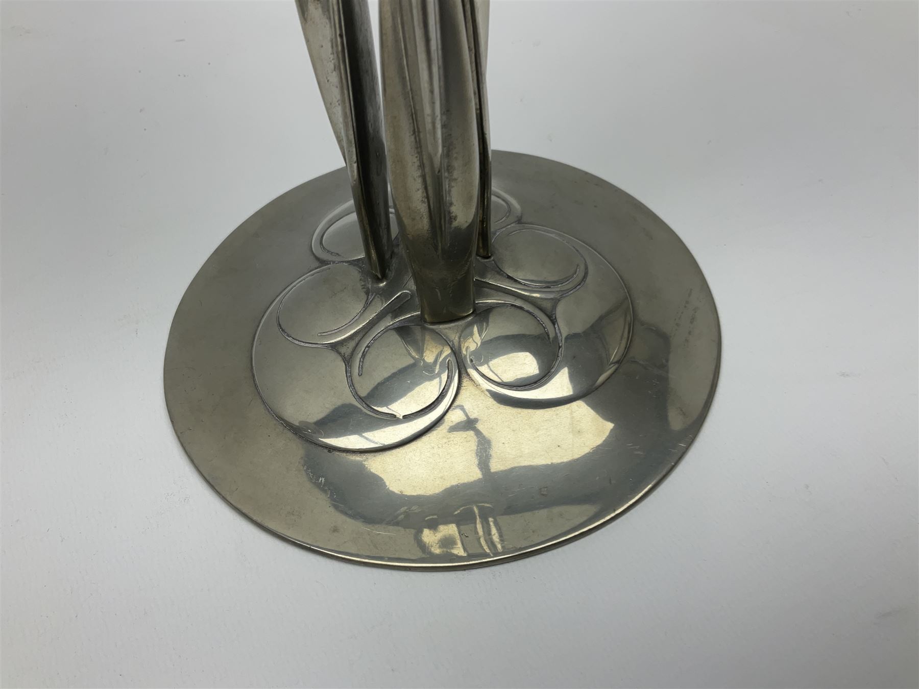 Archibald Knox (1864-1933) for Liberty & Co, pair of Tudric pewter candlesticks, the bud shaped sockets raised upon three angular fin supports and a slightly domed circular base with cast stylised foliate decoration, each stamped beneath Tudric 0223, H30cm