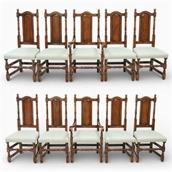 Country House oak high back dining chairs, set of ten comprising eight side chairs and two carvers, each with arched top rail flanked by turned finials over a central fielded panel back, with overstuffed seats upholstered in pale fabric, raised on turned front supports united by stretchers