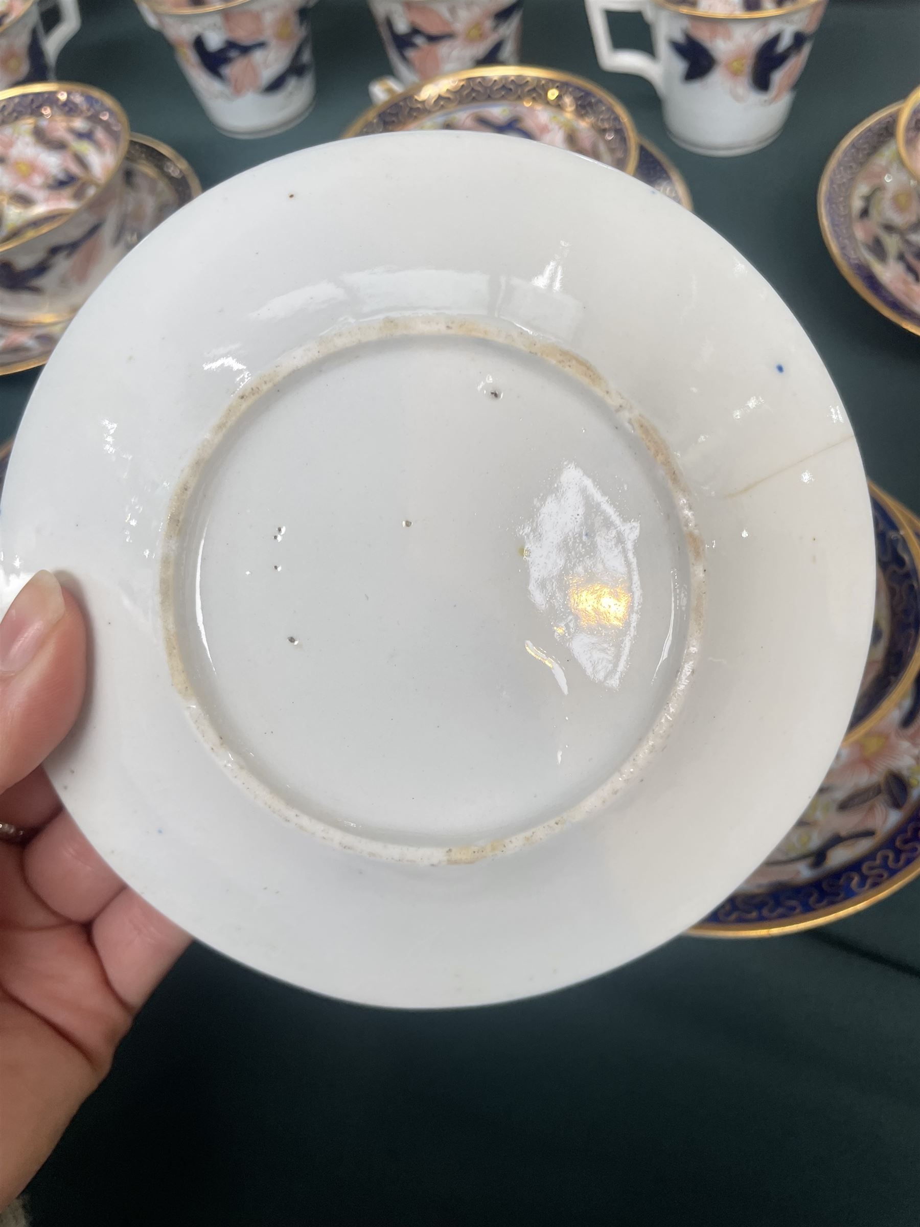 English porcelain Imari tea and coffee wares, pattern 1277, decorated with central orange floral motif surrounded by sprigs of yellow foliage within blue borders, comprising eleven teacups, eight coffee cups, twelve saucers, two shallow bowls and one finger bowl