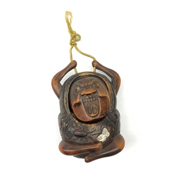 A Japanese carved soft wood inro, modelled as a streching and yawning figure, possibly Daruma, detailed with insect, inset mother of pearl butterfly, and glass eyes, H10cm. 