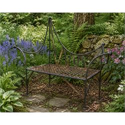 Victorian design wrought iron garden bench, with asymmetrical rope-twist frame, arched bac...