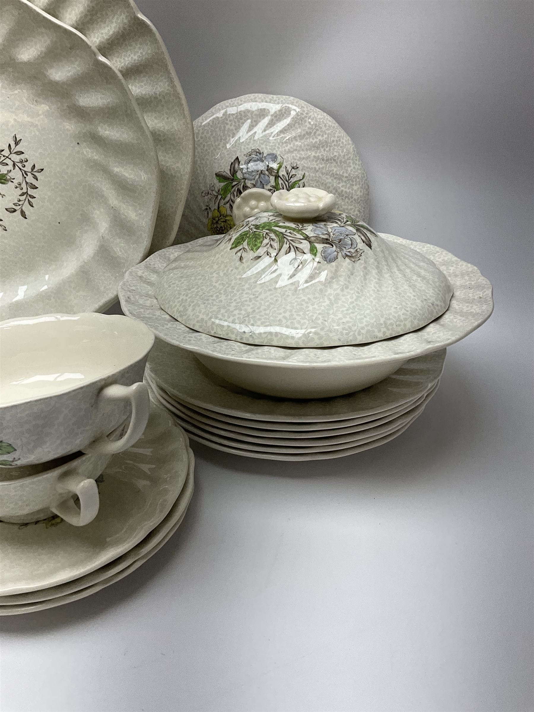 Royal Doulton dinner wares decorated in the Sutherland pattern, comprising two serving platters, one tureen and cover, six twin handled soup bowls and saucers, eight bowls, six dinner plates, seven side plates, and jug. 