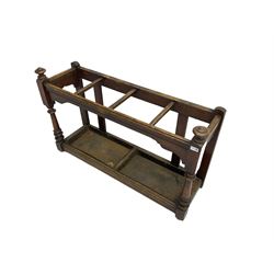 Edwardian oak hallway stick and umbrella stand, four divisions on turned supports, with metal tray liners and various sticks