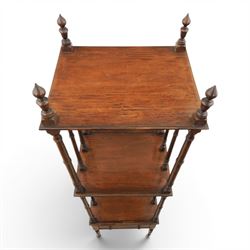 Late Victorian mahogany whatnot, the three tiers supported by turned spindle uprights with turned finials, fitted with a single frieze drawer, raised on turned supports with brass castors