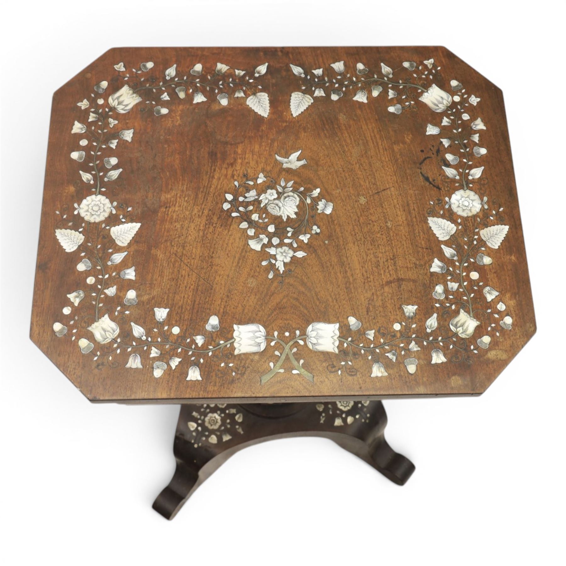 Victorian mahogany and mother-of-pearl inlaid work table, the octagonal hinged top enclosing a mirror and fitted compartmented interior, raised on a carved pedestal and quatriform platform base with scrolled feet