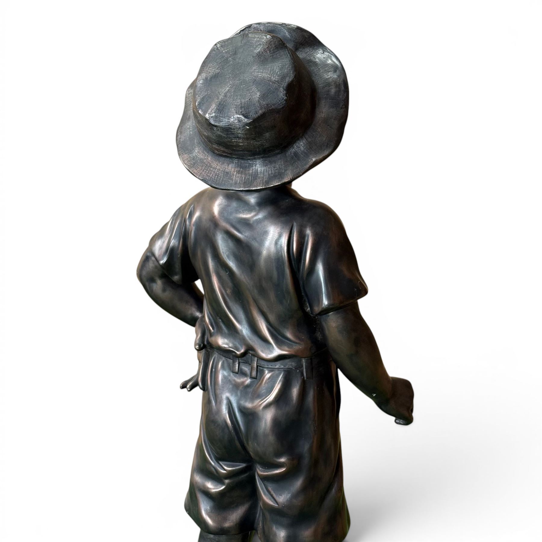 Bronzed composite figure of a boy wearing a hat, on circular plinth