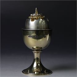 Late 20th century silver-gilt novelty surprise egg by Anthony Gordon Elson, the egg cup containing a  removeable shell, lifting to reveal a parcel gilt egg basket beneath, hallmarked Anthony Gordon Elson, London 1979, H11cm