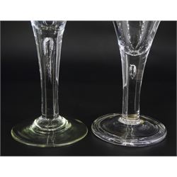 Two 18th century drinking glasses, the drawn trumpet bowls upon stems with internal tears, one elongated, and conical feet, one folded, largest H16cm