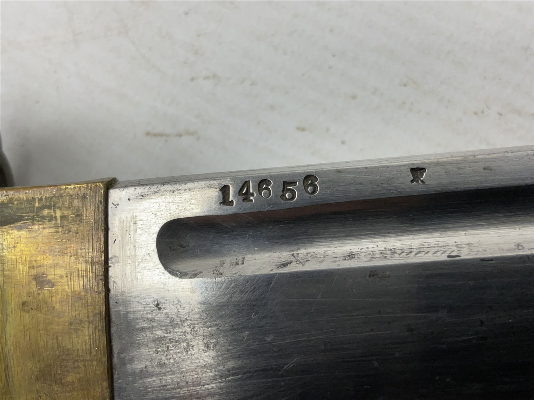 WW2 Japanese Army NCOs sword - katana, the 69.5cm slightly curving fullered blade numbered 14656; arsenal markings stamped near the habaki on the handle; brass tsuba and black painted metal hilt cast to simulate cord bound fish skin; in black painted steel scabbard with single suspension ring L96cm overall